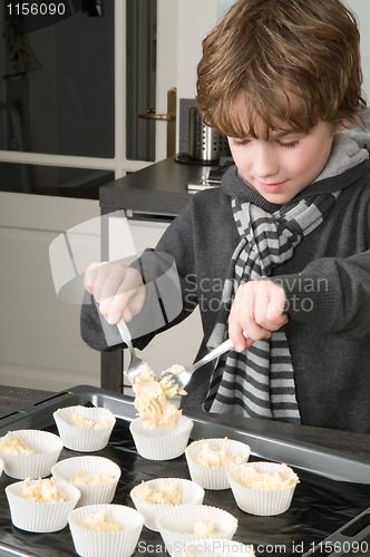 Image of Kid Filling Cakecups With Dough