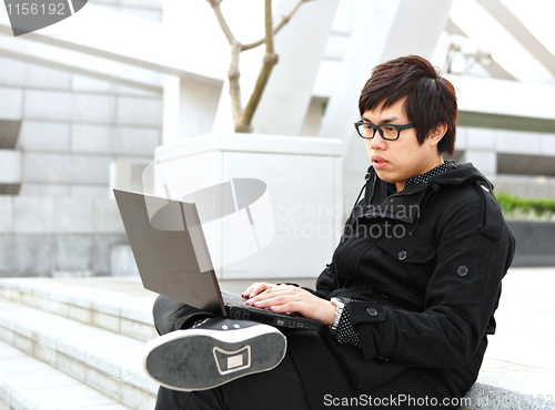 Image of man using computer outdoor 