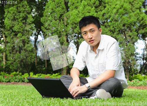 Image of man using computer outdoor