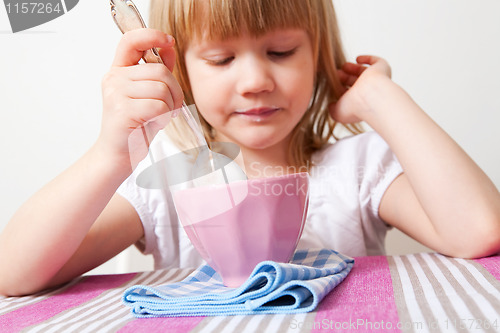 Image of Little girl eating breakfast