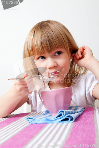 Image of Little girl eating breakfast