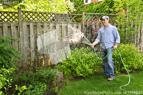 Image of Man watering garden