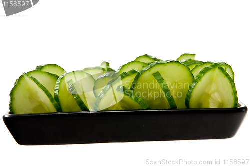 Image of Sliced cucumber stacked on a black plate