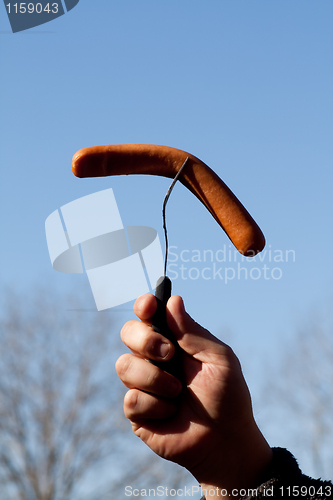 Image of Hand holding sausage