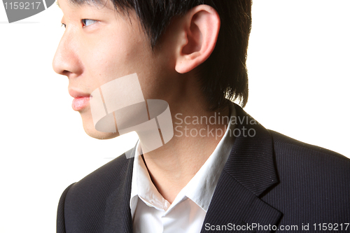 Image of Young businessman standing and looking right,