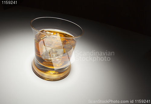 Image of Glass of Whiskey and Ice Under Spot Light