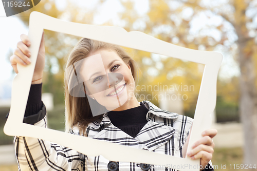 Image of Pretty Young Woman Smiling in the Park with Picture Frame