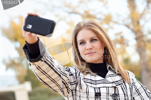 Image of Pretty Young Woman Taking Picture with Camera Phone