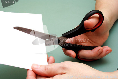 Image of women hand  cutting paper with scissors