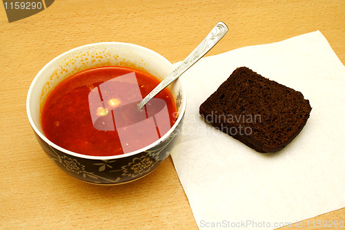 Image of An overhead view tomator soup with bread
