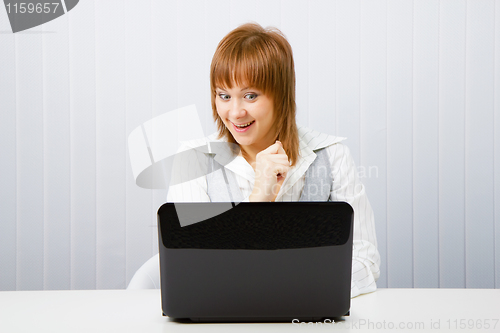 Image of joyful surprise a girl with a laptop