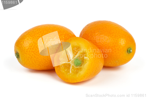 Image of Two whole and sliced kumquat fruits