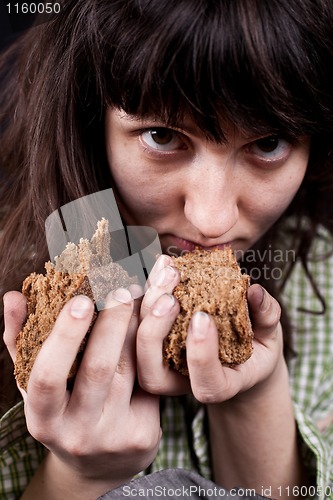 Image of beggar woman with a piece of bread in her hands