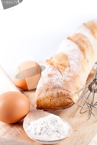 Image of bread, flour, eggs and kitchen utensil 