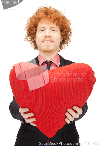 Image of handsome man with red heart-shaped pillow