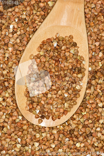 Image of Wooden spoon with uncooked buckwheat