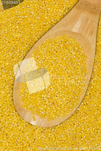 Image of Wooden spoon with uncooked millet