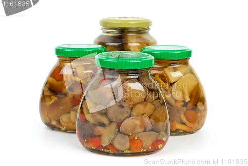 Image of Four glass jars with marinated mushrooms