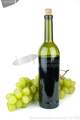 Image of Bottle with red wine and green grapes near