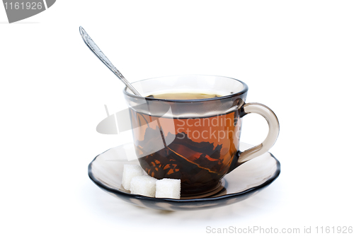 Image of Teacup with black tea, teaspoon, dish and some sugar pieces