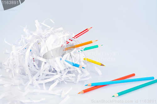 Image of Colored pencils and shredded paper ball over light blue background