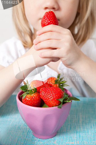 Image of LIttle girl eating strawberries