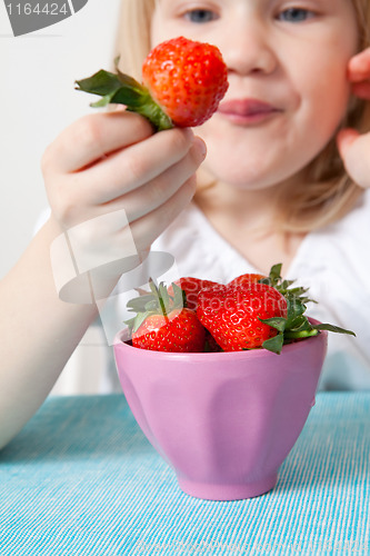 Image of LIttle girl eating strawberries