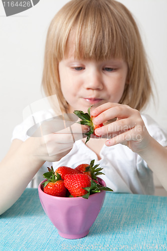 Image of LIttle girl eating strawberries