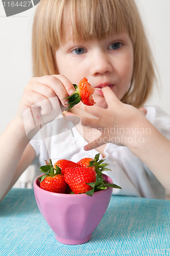 Image of LIttle girl eating strawberries