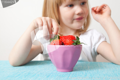 Image of Little girl with a bowl of strawberries