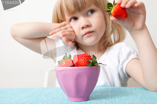 Image of Little girl with a bowl of strawberries