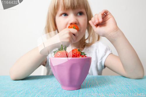 Image of LIttle girl eating strawberries