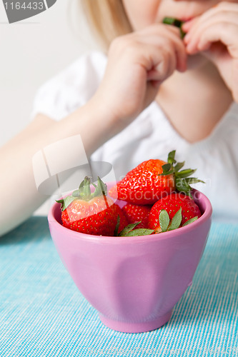 Image of LIttle girl eating strawberries