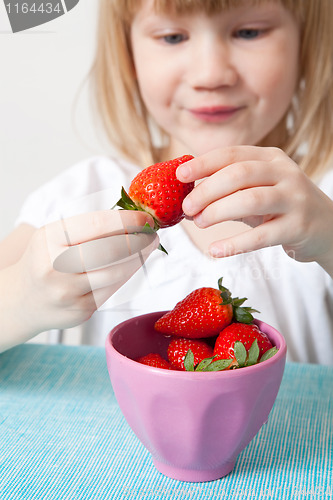 Image of Little girl with a bowl of strawberries