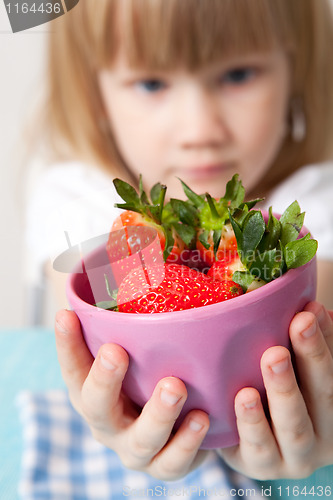 Image of Little girl with a bowl of strawberries