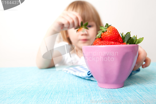Image of Little girl with a bowl of strawberries