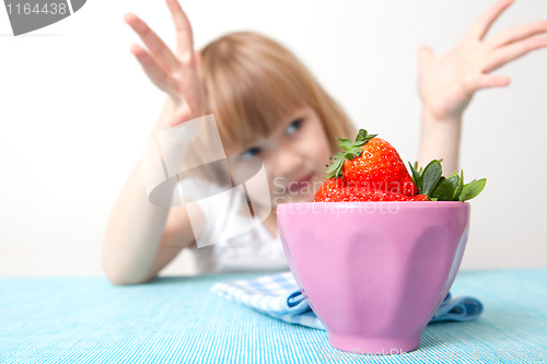 Image of Little girl with a bowl of strawberries