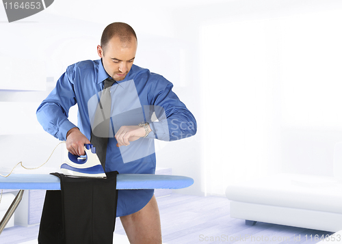 Image of businessman ironing his trouser