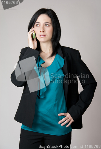 Image of Worried business woman talking on the cell phone