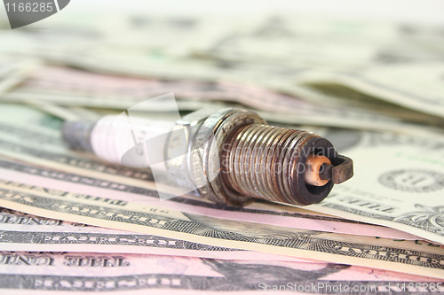 Image of spark plug on dollar bills