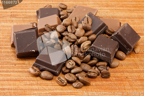 Image of Chocolate and coffe beans on wooden plate