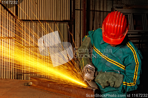 Image of heavy industry manual worker with grinder 