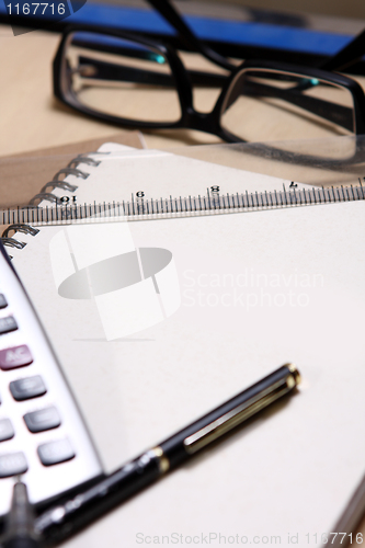 Image of pen ,book, ruler, calculator and glasses