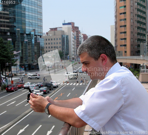 Image of Man with mobile phone in a city