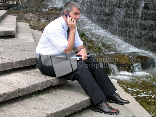 Image of Man with phone and computer