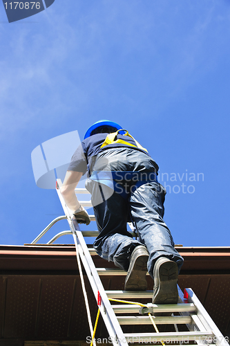 Image of Construction worker climbing ladder