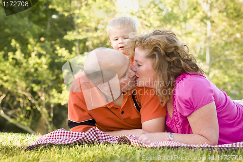 Image of Affectionate Couple Kiss as Cute Son Looks On