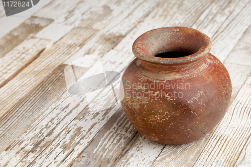 Image of red clay pot on rustic table