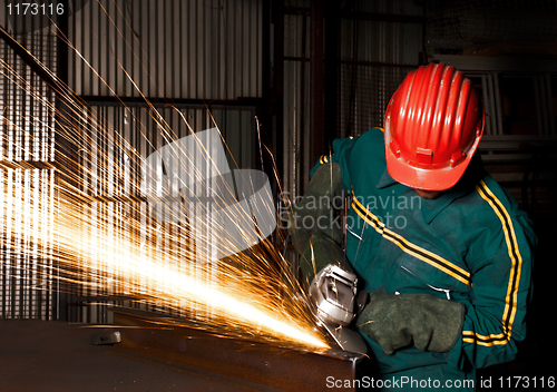 Image of heavy industry manual worker with grinder