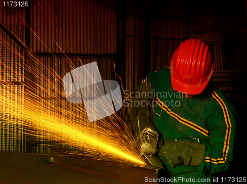 Image of heavy industry manual worker with grinder 